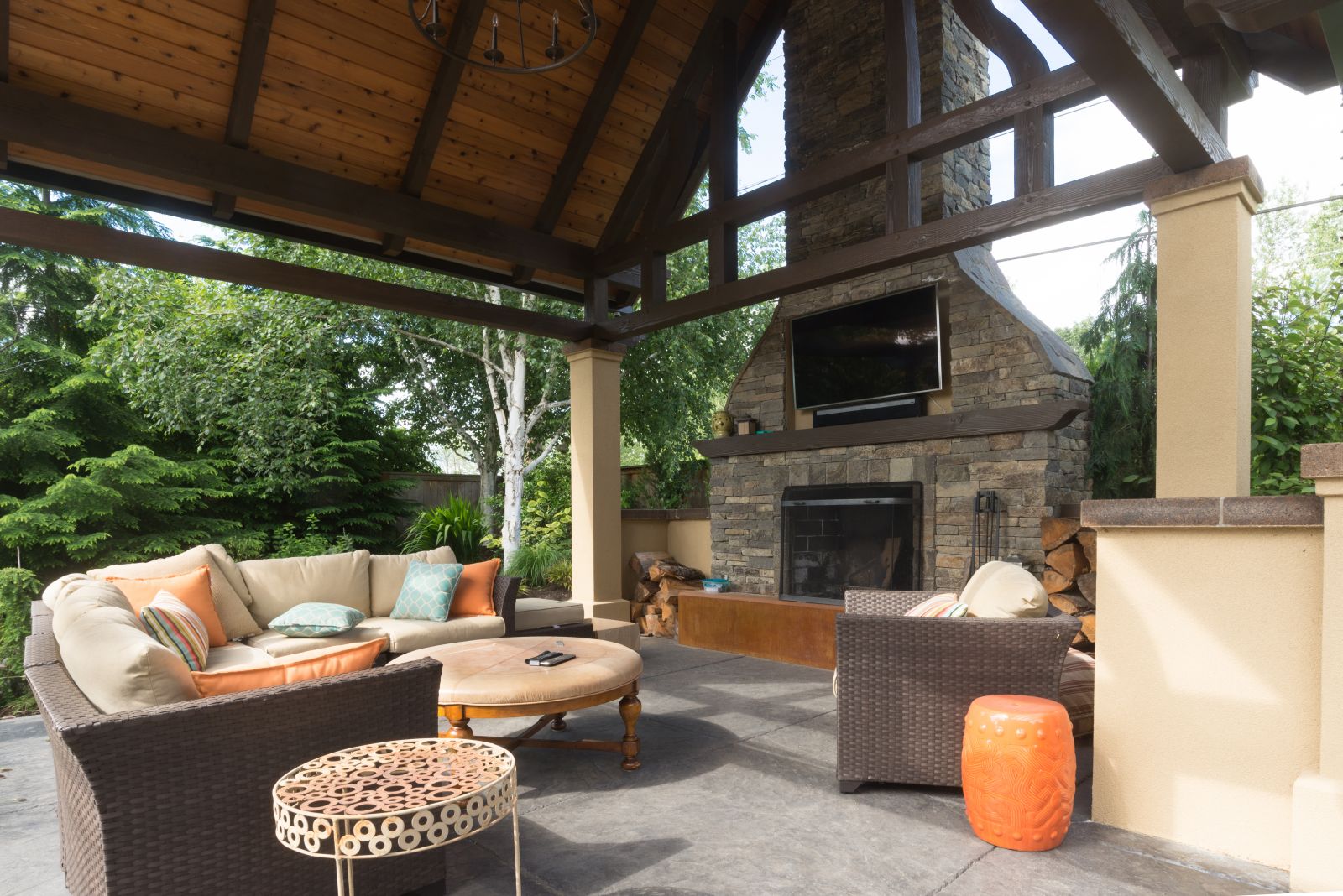 open outdoor living space with stone fireplace and wood pergola