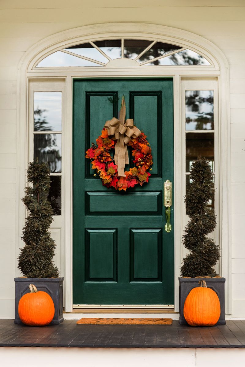 green front door with fall decorations 