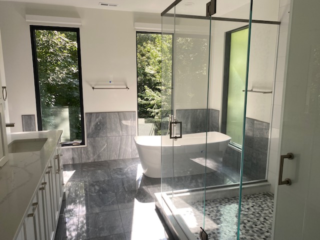 Modern bathroom with floor to ceiling windows and glass shower walls