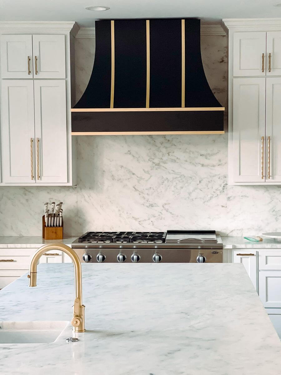 Modern kitchen with marble counters and hood by top remodelers in Millersville and Baltimore, MD