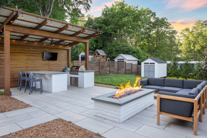 Outdoor kitchen with grill and seating area designed by American Cedar partner Setting sun Patios
