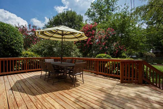A deck with a table and umbrella