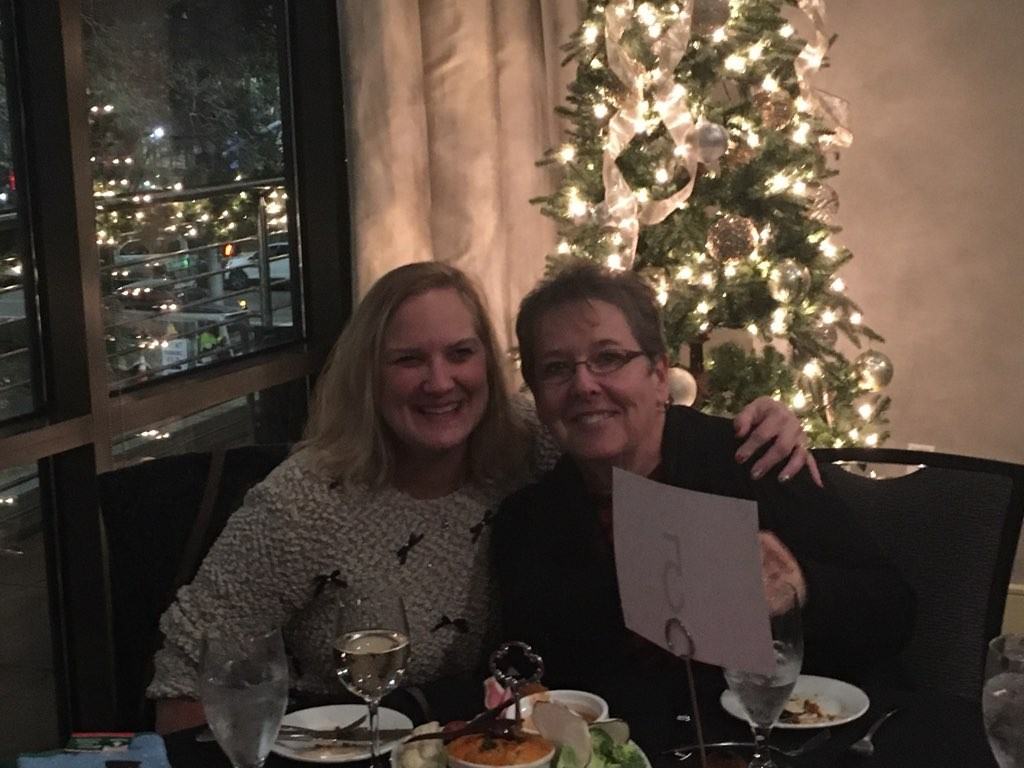Holiday party attendees gathered beside a decorated Christmas tree at Raleigh event 2019