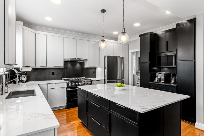 Modern black and white kitchen with large island and pendant lighting