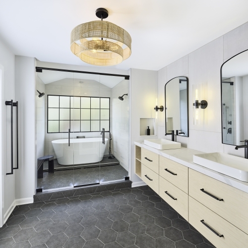 Contemporary light bathroom in Millersville, MD, featuring a large mirror and a stylish tub