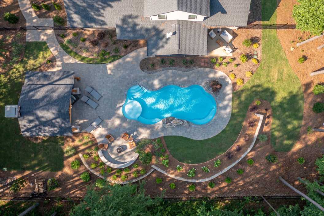 A backyard oasis featuring a freeform swimming pool and adjacent landscaping