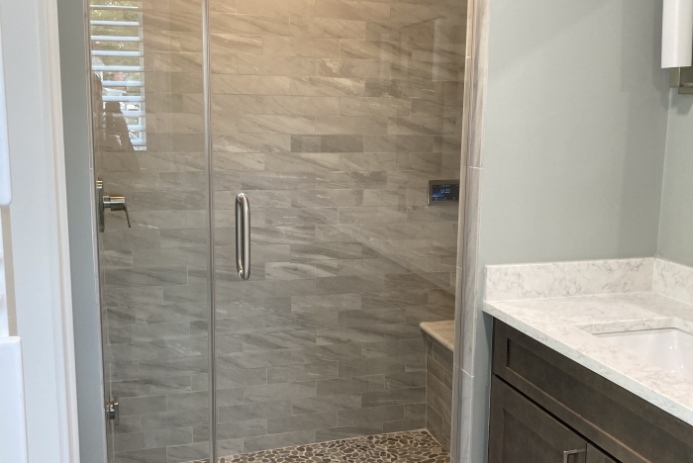 A contemporary bathroom with a glass shower door and sink in Baltimore, MD