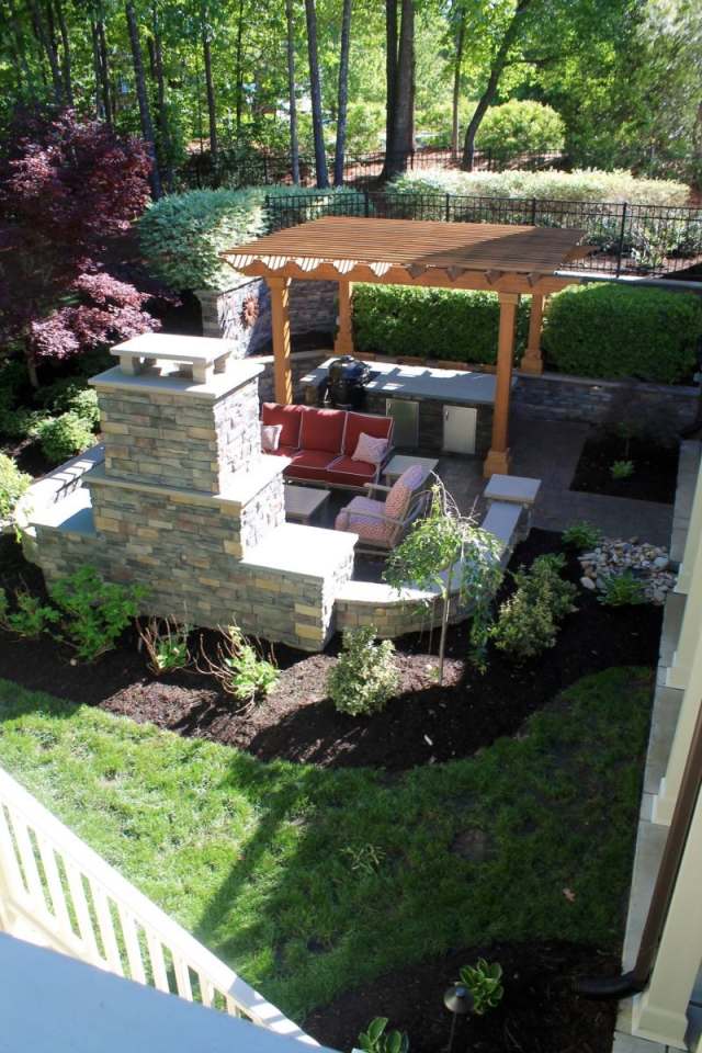Rustic outdoor living space featuring a stone fireplace and a Western Red Cedar pergola