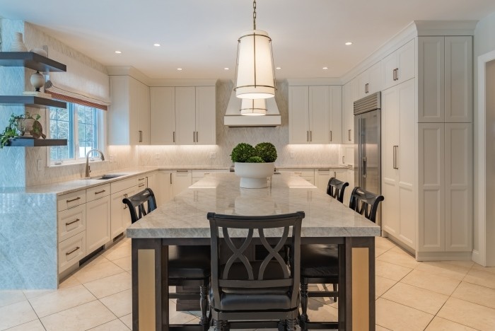 Kitchen cabinets with veined stone countertop and under-cabinet lighting