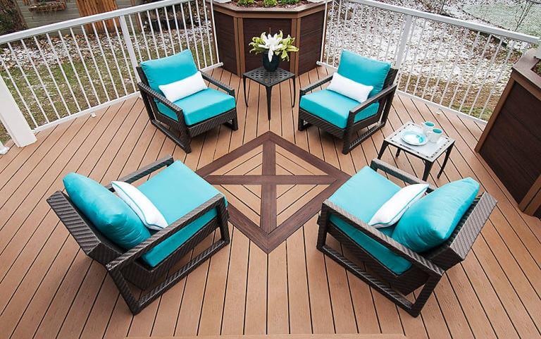 Outdoor deck seating with four chairs, teal cushions, small table, and wooden flooring design