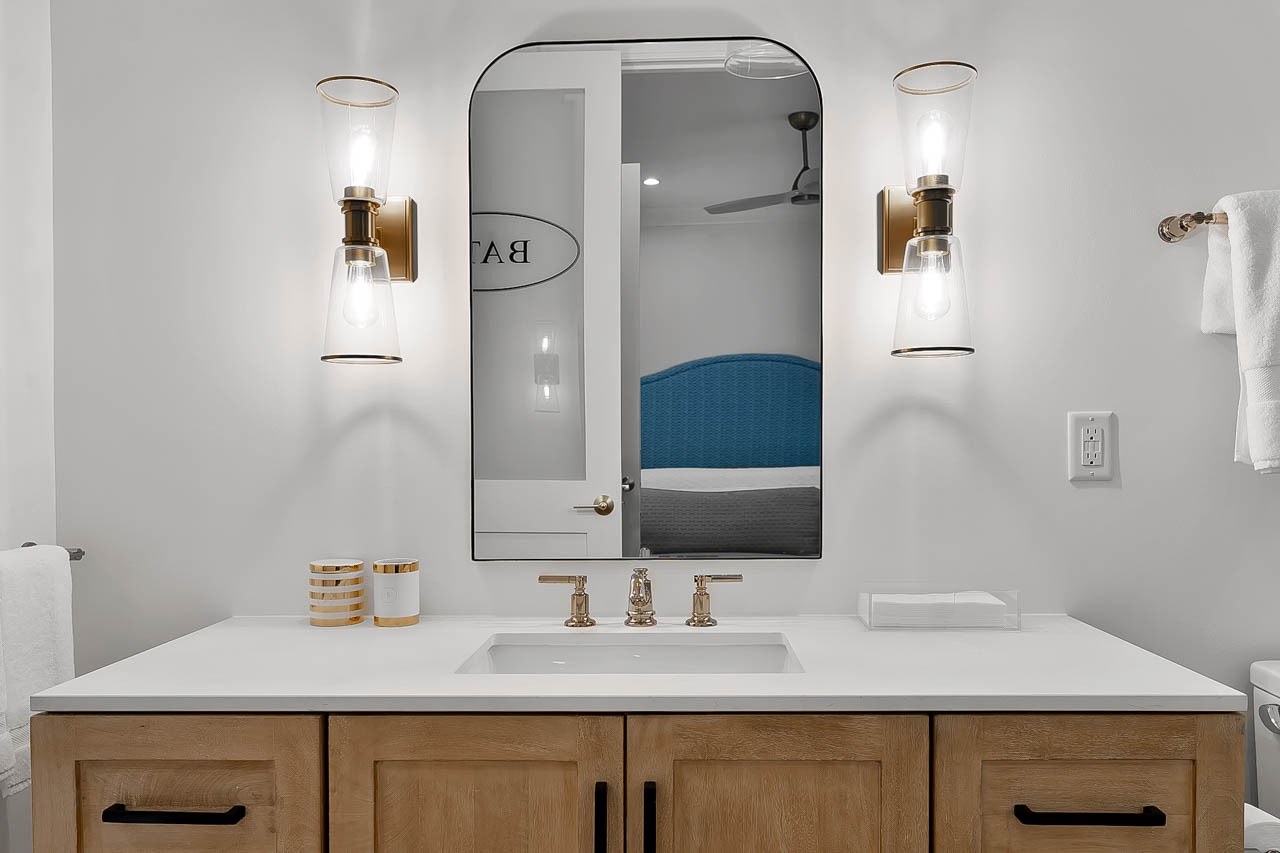 Natural wood bathroom vanity with quartz countertop in a custom poolhouse retreat