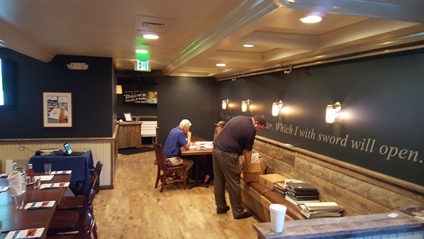 A man stands at a restaurant table during a company event in Millersville and Baltimore, MD