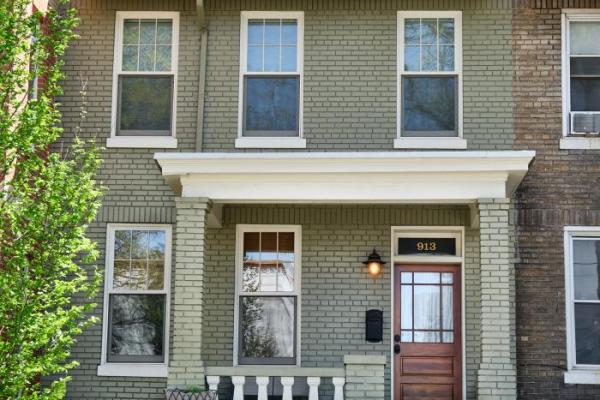 Brick home exterior with custom windows and wooden front door design