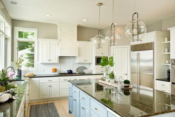 Modern kitchen with custom cabinetry and stone countertops by American Cedar & Millwork