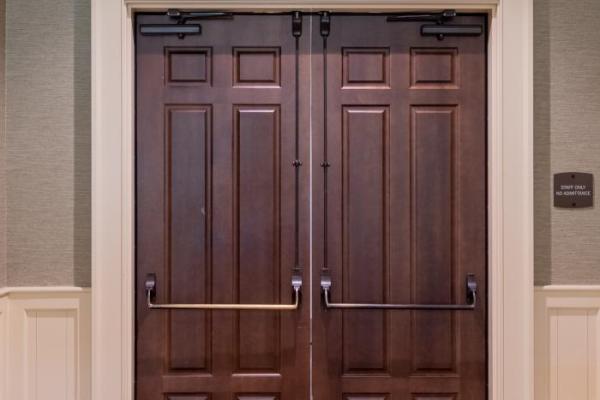Solid wood double doors with panels and metal push bars in entryway