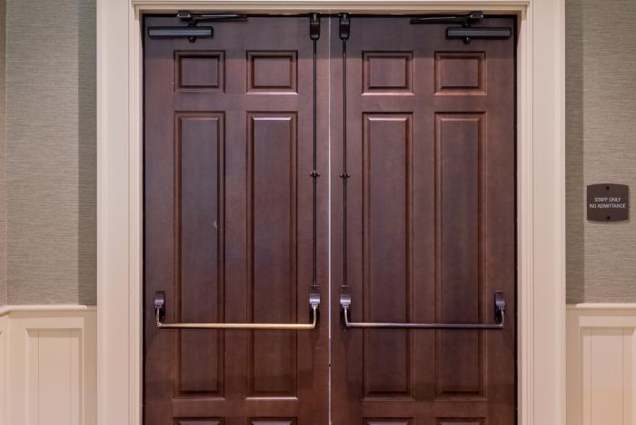 Solid wood double doors with panels and metal push bars in entryway