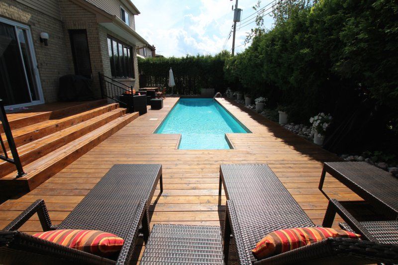 Western Red Cedar deck with a pool and patio furniture in Millersville, MD, surrounded by greenery