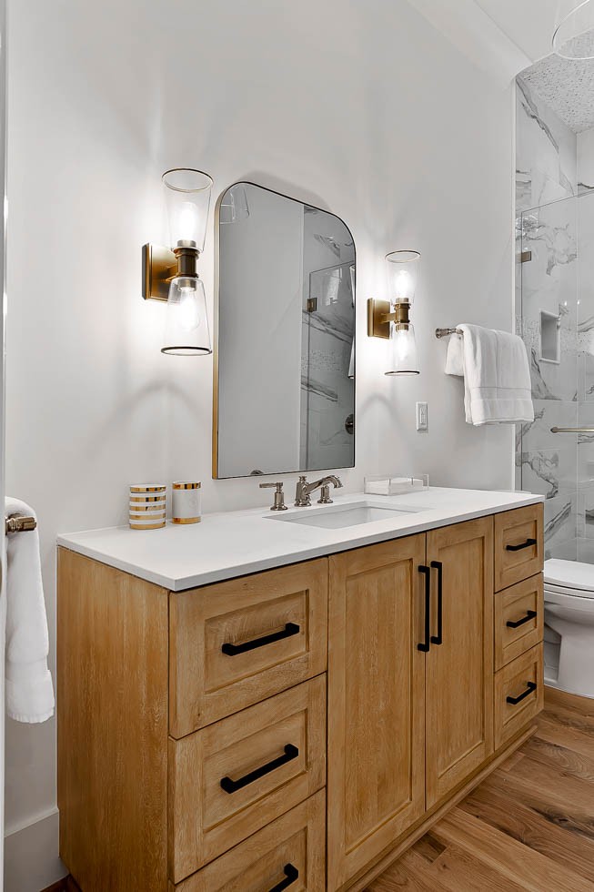 Natural wood vanity with quartz countertop in a bright custom poolhouse bathroom