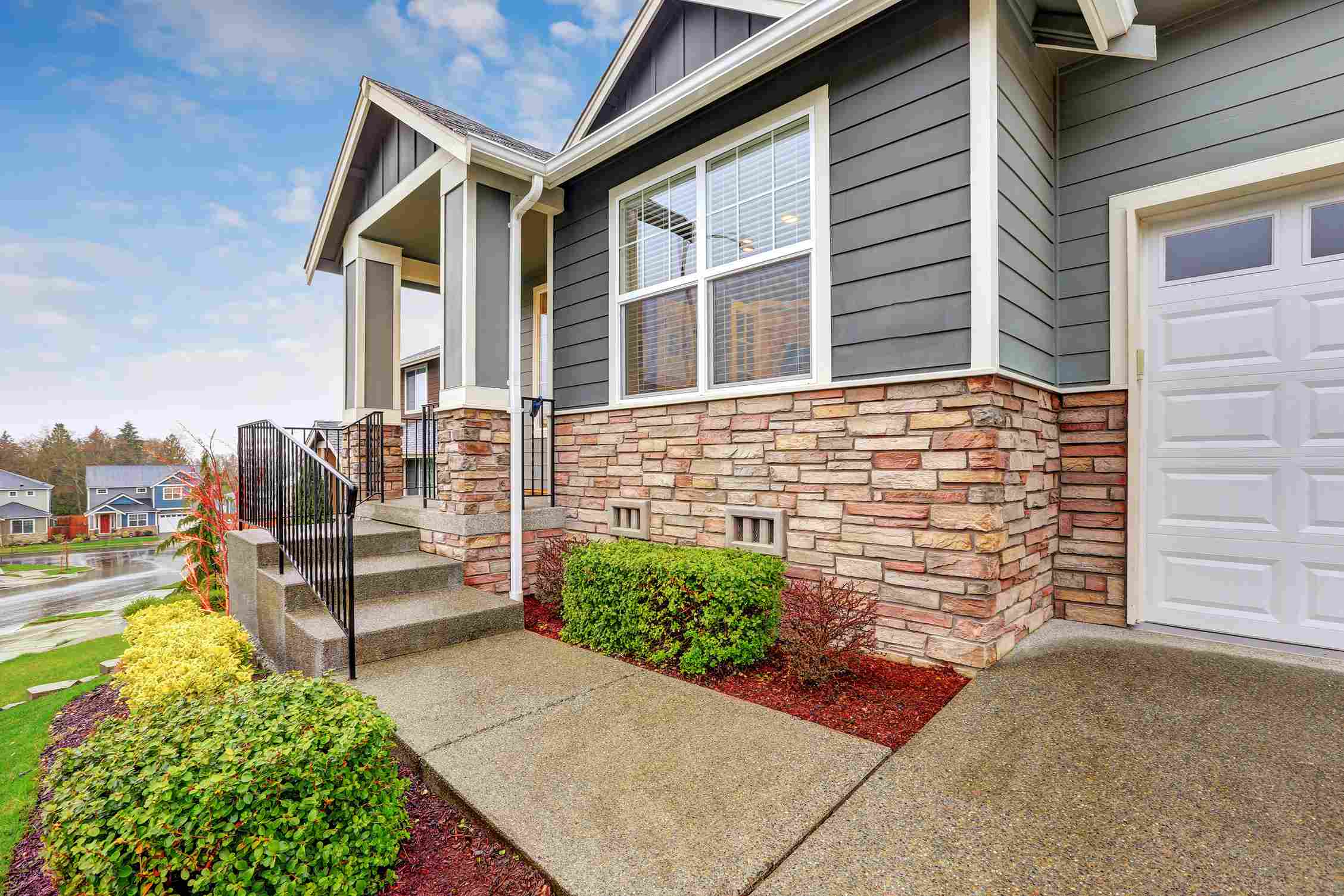 A charming porch in Raleigh, NC, showcasing rocking chairs and a porch light,